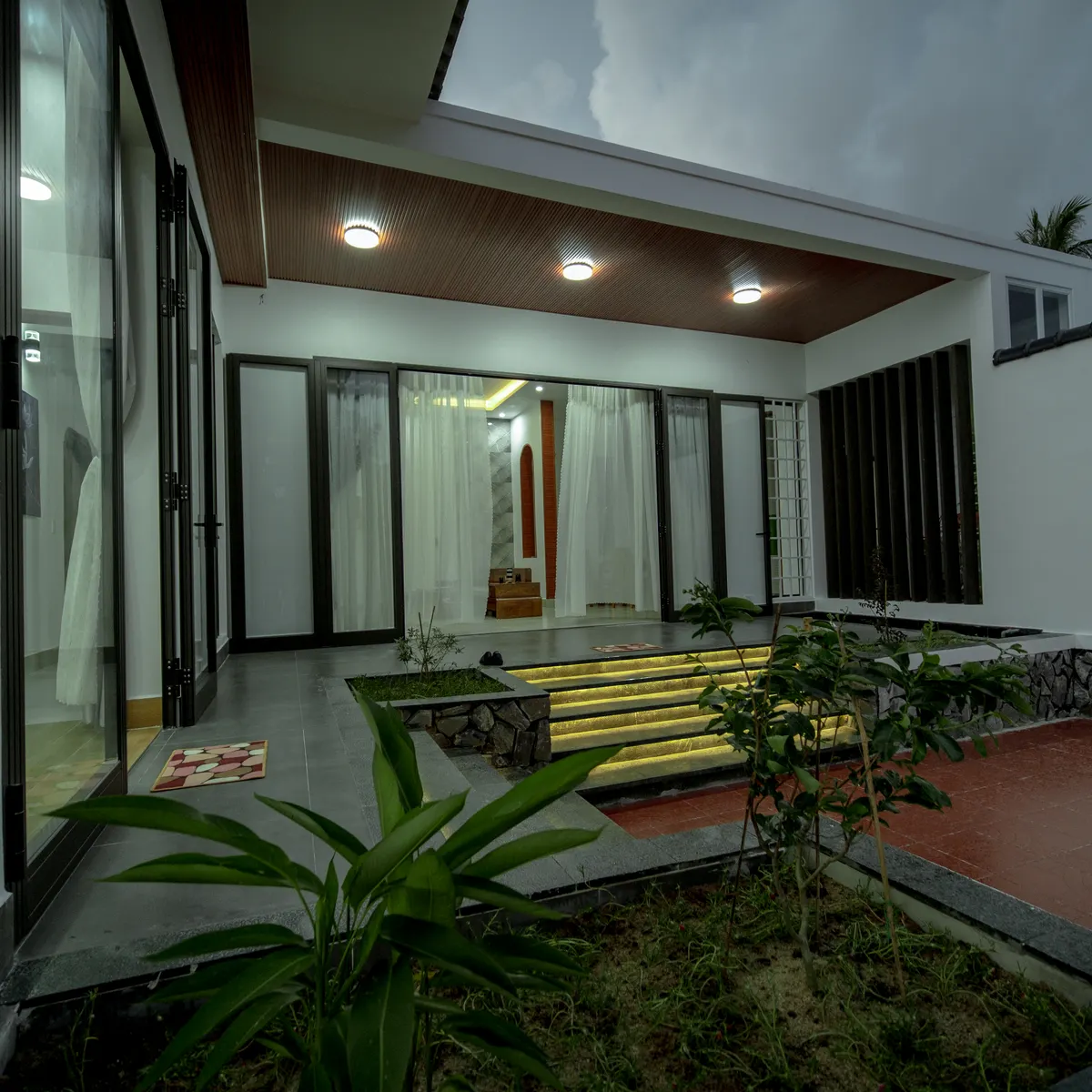 Foto ilustrasi halaman rumah dengan lampu menyala saat senja